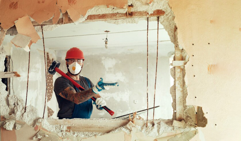 trabajador tumbando pared