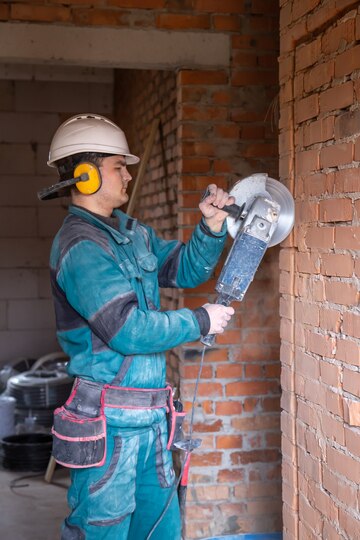 electricista trabajador de la construcción casco-protector instalación de trabajo trabaja con amoladora